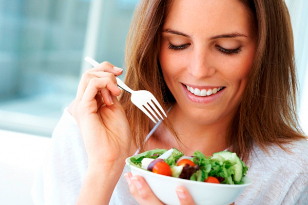 Imagen de una mujer comiendo una ensalada