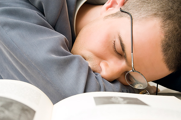 Imagen de un chico descansando encima de un libro