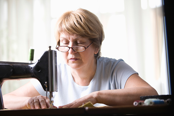 Imagen de una mujer cosiendo con gafas