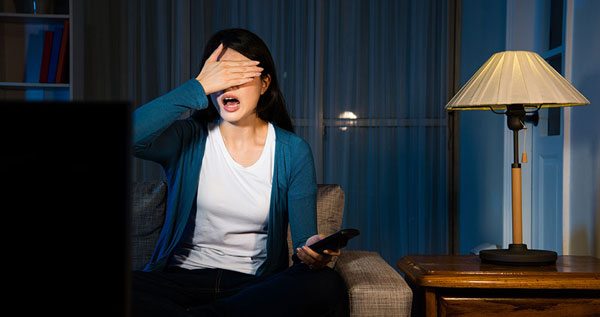 Chica viendo la televisión a oscuras