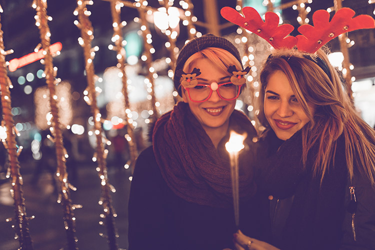 Chicas en la calle iluminadas por las luces de Navidad