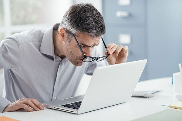 Hombre con hipermetropía ajustando visión al ordenador