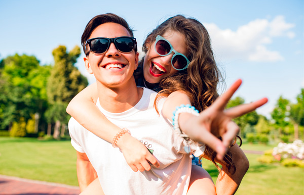 Salud Visual, niveles de protección. Una pareja feliz en el parque con gafas de sol