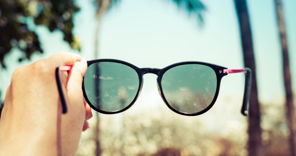 Salud Visual, niveles de protección. Una pareja feliz en el parque con gafas de sol