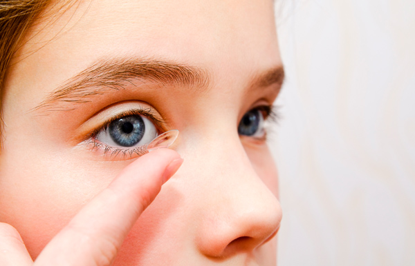 Método Orto-K, lentes de contacto mientras duermes para controlar la miopía. Niña poniéndose las lentillas