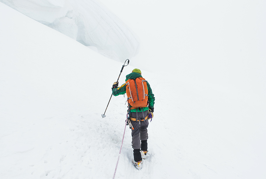 Montañero en una montaña nevada escalando