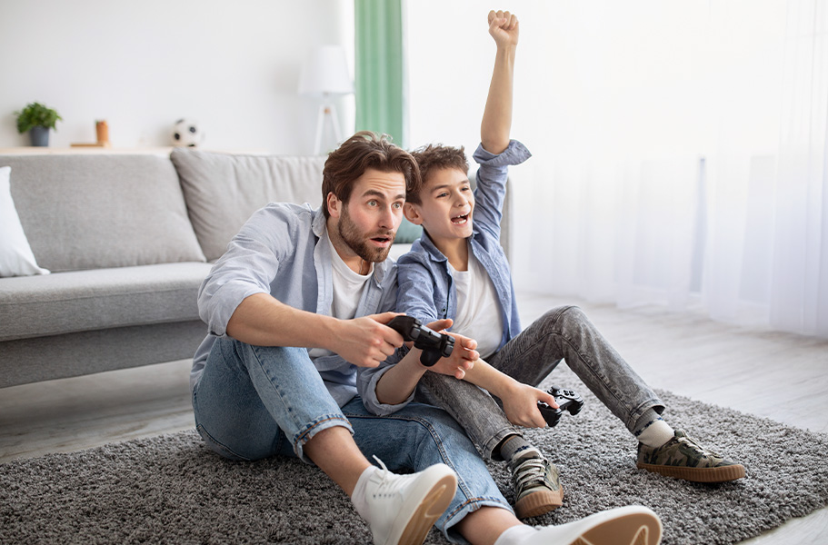 Padre e hijo jugando juntos a videojuegos.