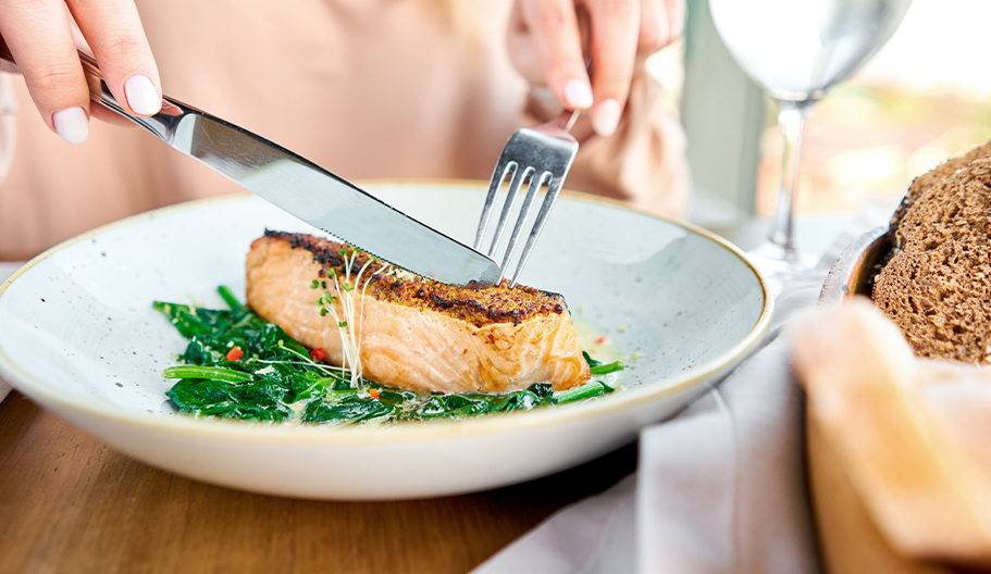 Persona comiendo salmón, pescado azul