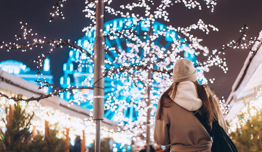 Chica mirando las luces de Navidad en la calle