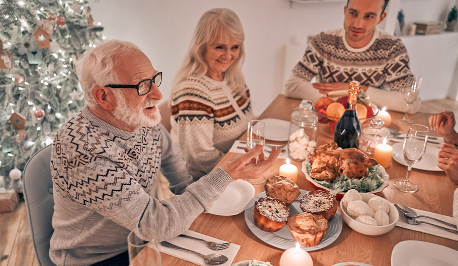 Hombre con gafas cenando con su familia en Navidad