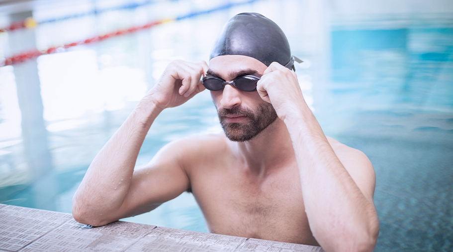 Hombre en la piscina con gafas de natación