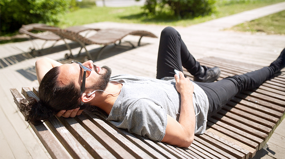 Chico echando la siesta al sol con gafas de sol