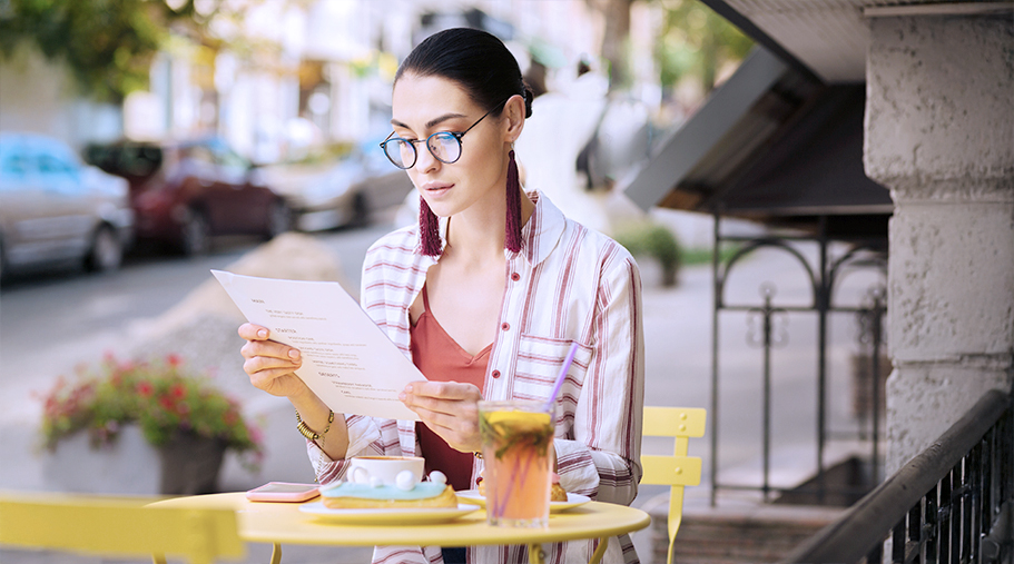 Chica con gafas leyendo el menú de un restaurante