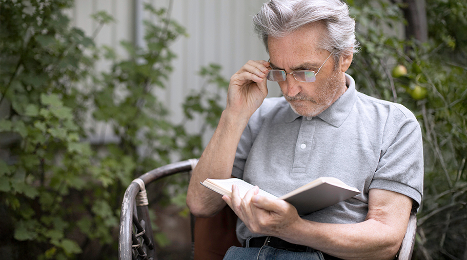 Señor de avanzada edad ajustandose las gafas para leer