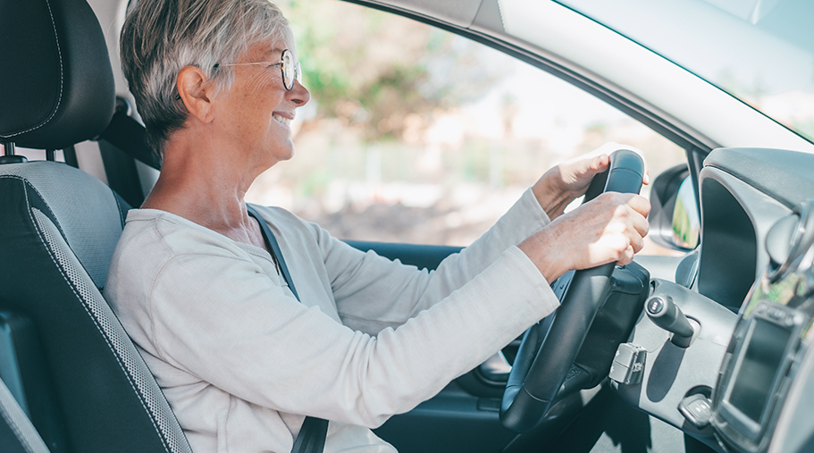Mujer madura con gafas conduciendo