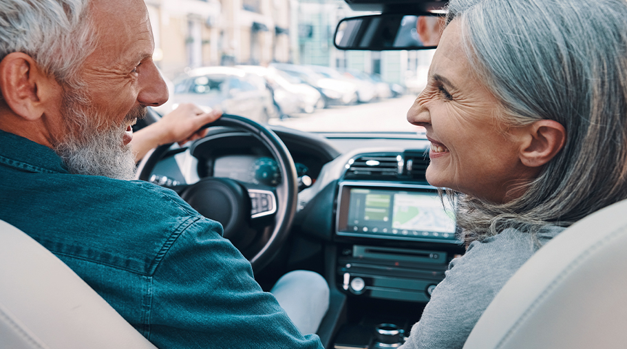 Pareja de hombre y mujer maduros felices en el coche