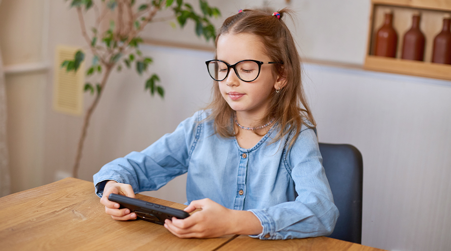 Niña jugando a videojuegos en una mesa