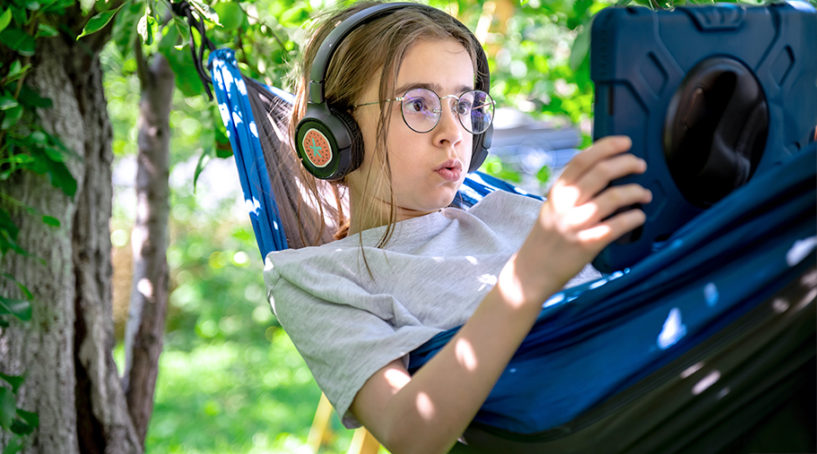 Niña jugando a videojuegos en una tumbona